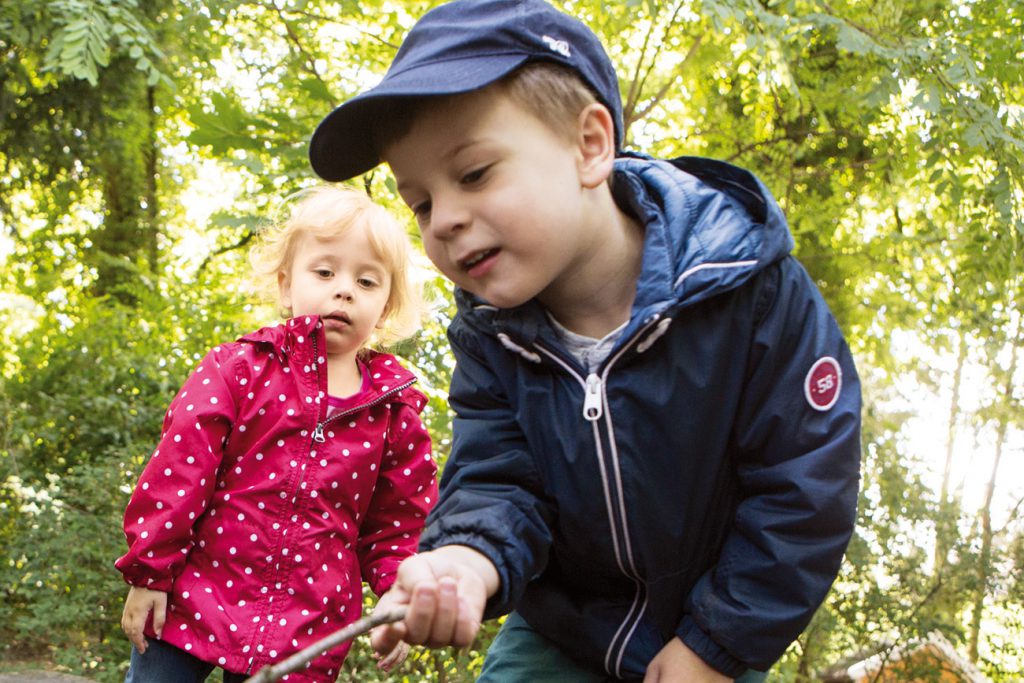 Junge und Mädchen spielen mit Wald