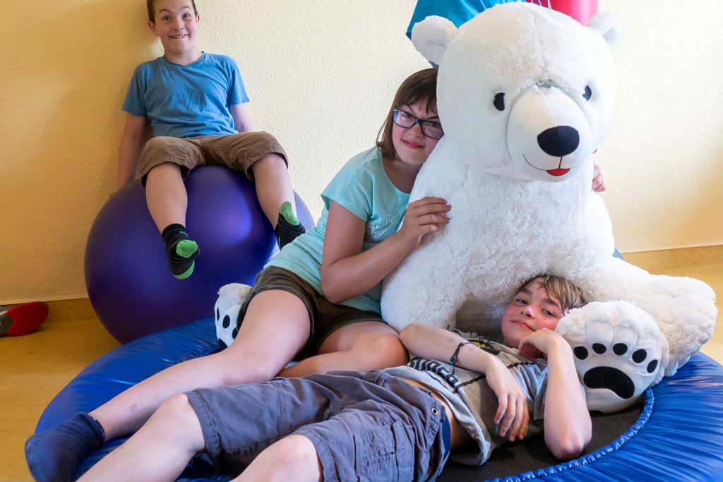 Drei Kinder mit Riesen Kuscheltier