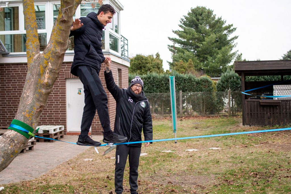 Jugendlicher und Erzieher mit Slackline