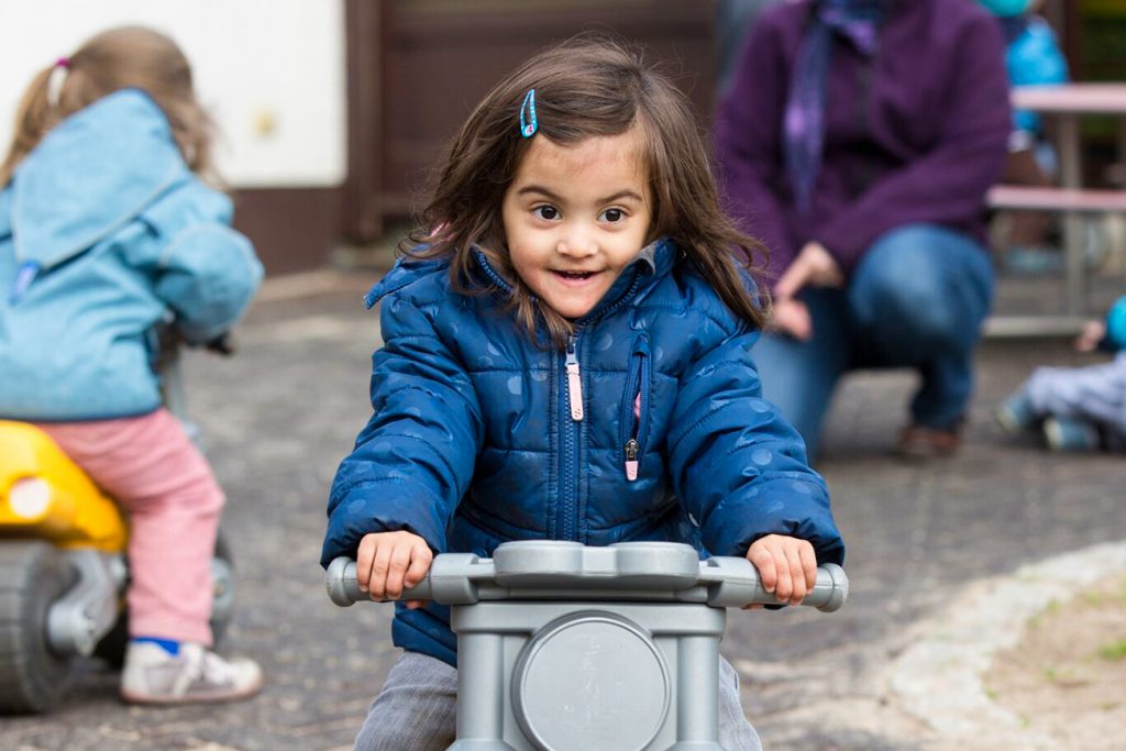 Mädchen mit Spielzeugmotorrad